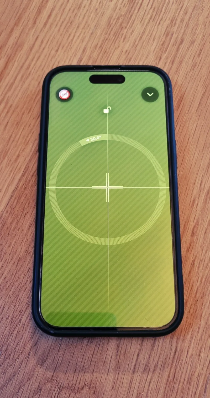 Smartphone lying flat on a table showing 0.0° on the bubble level app